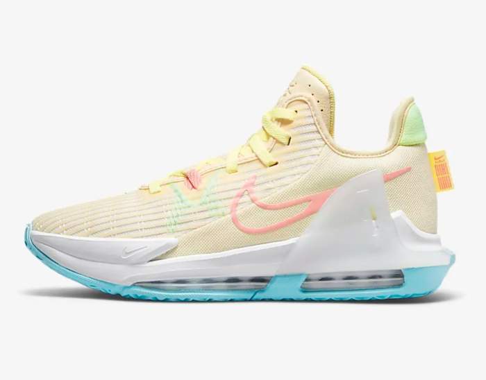 Side view of cream and blue Nike basketball shoe.